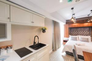 uma cozinha com um lavatório e uma cama num quarto em Zebbuga The Penthouse Suite 7 em Żebbuġ