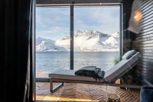 a view of the snow covered mountains from a window at Skipperhuset 1, Bernt Berntsen suite in Tofta
