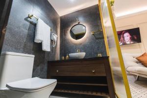 La salle de bains est pourvue d'un lavabo, de toilettes et d'un miroir. dans l'établissement Zebbuga Deluxe Balcony Suite Apartment 4, à Żebbuġ