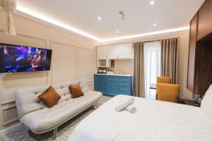 1 dormitorio con cama blanca y sofá en Zebbuga Deluxe Balcony Suite Apartment 4, en Żebbuġ