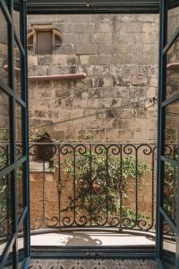 a view from an open window of a brick wall at Zebbuga Deluxe Balcony Suite Apartment 4 in Żebbuġ