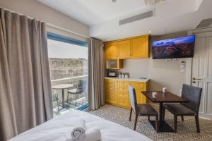 a hotel room with a bed and a table and a kitchen at Iz-Zebbuga The Penthouse Royal 8 in Żebbuġ