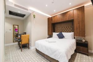 a bedroom with a large bed with a wooden headboard at Zebbuga Deluxe Balcony Apartment 6 in Żebbuġ