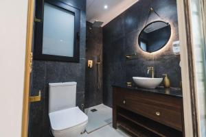 ein Badezimmer mit einem WC, einem Waschbecken und einem Spiegel in der Unterkunft Zebbuga Tranquil Suite with Balcony 5 in Żebbuġ