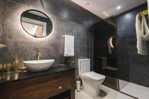 a bathroom with a sink and a toilet and a mirror at Zebbuga Deluxe Lavish Suite 3 in Żebbuġ