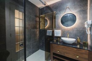 a bathroom with a sink and a shower with a mirror at Zebbuga Deluxe Lavish Suite 3 in Żebbuġ