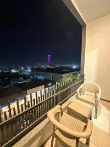 a balcony with two chairs and a table and a view at MyFlower 3 Hotel in Erbil