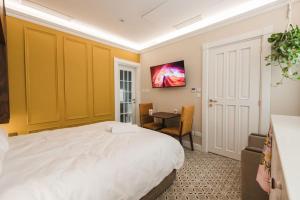 a bedroom with a bed and a desk and a tv at Zebbuga Lavish Suite 2 in Żebbuġ