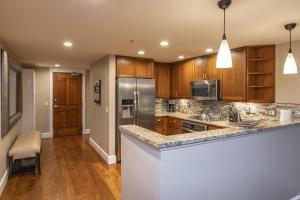 eine Küche mit Holzschränken und Geräten aus Edelstahl in der Unterkunft River Club 306 by Alpine Lodging Telluride in Telluride + 38 Fotos