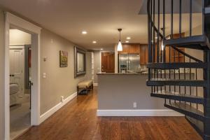 ein Wohnzimmer und eine Küche mit einer Wendeltreppe in der Unterkunft River Club 306 by Alpine Lodging Telluride in Telluride