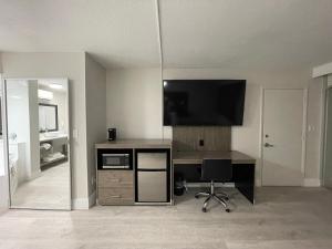 Habitación con escritorio, TV y silla. en Quality Inn & Suites Airport - Cruise Port Hollywood, en Hollywood