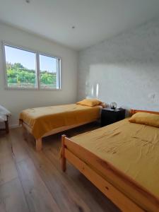 1 dormitorio con 2 camas y ventana en Maison de vacances 3 chambres, en Locquirec