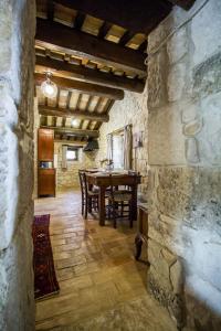a dining room with a table and a stone wall at One bedroom apartement with enclosed garden and wifi at Abbateggio in Abbateggio