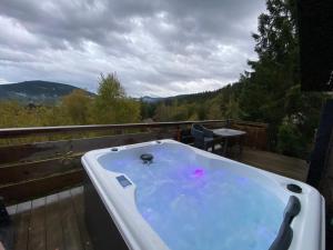 a bath tub on a deck with a view of the mountains at Le chalet des coeurs in Le Tholy