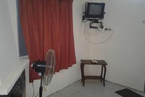 a room with a fan and a television and a table at Chalet Milagros in Costa Azul