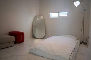 a white room with a bed and a mirror at BridgeStar001 Gangnam Sinsa Station Garosugil 6 Guests in Seoul