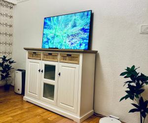 a flat screen tv on top of a white cabinet at Altheda Living Relax E4 in Suceava +7 photos