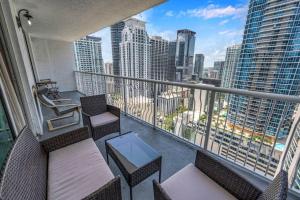 a balcony with chairs and tables and a view of the city at Iconic 1BR HighRise Condo Brickell-FreeParking in Miami