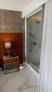 Hotel Nacional Rio de Janeiro في ريو دي جانيرو: حمام مع دش وطاولة مع مصباح