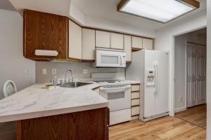 a kitchen with white appliances and wooden cabinets at Lighthouse Retreat II for Location and Romance in Wisconsin Dells