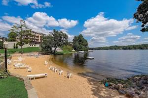 a beach with chairs and tables and water and a building at Lighthouse Retreat II for Location and Romance in Wisconsin Dells