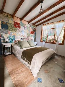 1 dormitorio con 1 cama grande en una habitación con paredes coloridas en Malibu Hostal Boutique, en Maitencillo