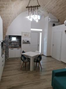 eine Küche und ein Esszimmer mit einem weißen Tisch und Stühlen in der Unterkunft SaLò Apartments in Manfredonia