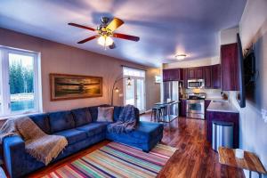 a living room with a blue couch and a ceiling fan at Lakefront Aviators Aurora Retreat in North Pole