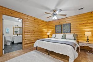 Schlafzimmer mit Holzwänden und einem Bett mit Deckenventilator in der Unterkunft Quiet Country Escape 