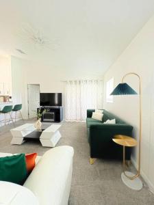 uma sala de estar com um sofá verde e uma mesa em Luxury Modern Pool House close to theme parks. em Kissimmee