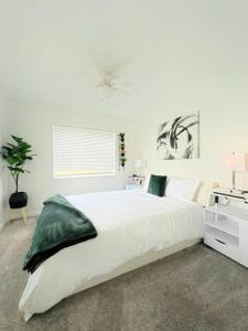 1 dormitorio blanco con 1 cama grande y lavamanos en Luxury Modern Pool House close to theme parks. en Kissimmee