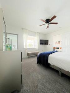 um quarto com uma cama e uma ventoinha de tecto em Luxury Modern Pool House close to theme parks. em Kissimmee