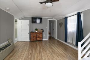 uma sala de estar vazia com uma ventoinha de tecto e pisos em madeira em Stone Cottage Retreat em Springfield