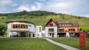 ein großes Haus mit einem Hügel im Hintergrund in der Unterkunft Weingut Peifer in Traben-Trarbach