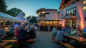 eine Gruppe von Personen, die vor einem Gebäude an Tischen sitzen in der Unterkunft Weingut Peifer in Traben-Trarbach