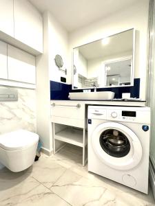 uma casa de banho com uma máquina de lavar roupa e um lavatório em Luxury Aparthotel orbi in black sea arena em Batumi