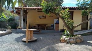 een klein huis met een tafel en een boom bij Casa integrada com a natureza in Palmeiras