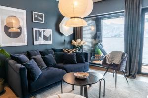 a living room with a blue couch and a table at Skipperhuset 2, Kristian Isaksen suite in Tofta