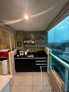 a kitchen with a counter in a room with a window at Apartamento Mongaguá in Mongaguá