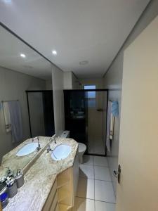 a bathroom with two sinks and a large mirror at Apartamento Mongaguá in Mongaguá