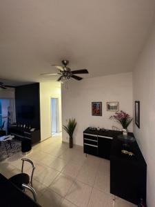 a living room with a ceiling fan and a couch at Apartamento Mongaguá in Mongaguá