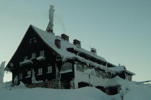 a building covered in snow with snow at Apartament Górski Raj in Świeradów-Zdrój