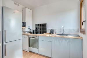 cocina con electrodomésticos blancos y nevera blanca en Confortable T2 / Clim + Parking, en Marmande