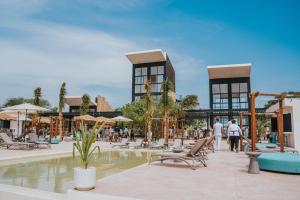 un resort con piscina con gente che ci cammina intorno di Totem Beach Club - Celestun a Celestún