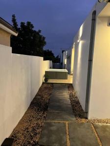 a walkway between two white buildings with a fence at Entre ciel et mer in Grand Baie