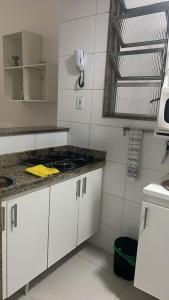 a kitchen with white cabinets and a phone on the wall at Copacabana Apartment in Rio de Janeiro