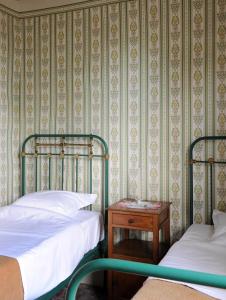 a bedroom with two beds and a nightstand with a table at Barak de Vinck in Ypres