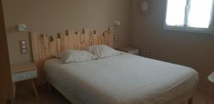 1 dormitorio con 1 cama grande y cabecero de madera en Gites Les Mondaines - Les hirondelles, en Favières