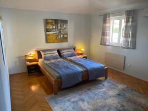 イチチにあるApartment Meerblick Opatija (Icici)の青いシーツのベッドと窓のある寝室