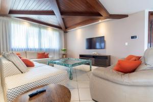 uma sala de estar com dois sofás e uma mesa em Luxo e Conforto na Praia de Cotovelo por Carpediem em Parnamirim